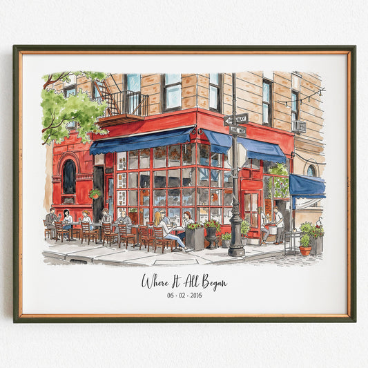 Framed artwork of a street scene with a red building and people sitting at outdoor tables.