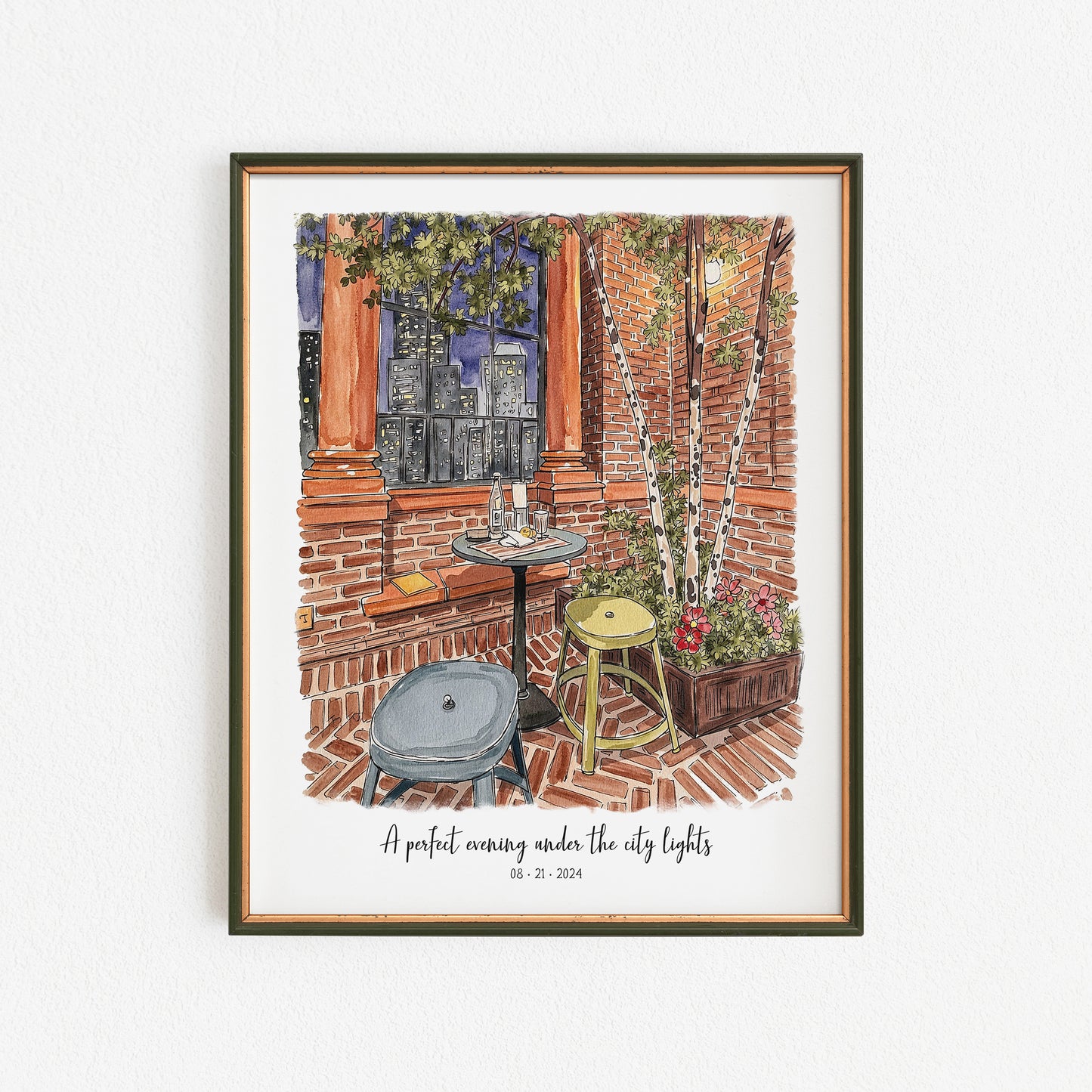 Framed artwork of an outdoor scene with a table and chairs, brick wall, and city lights.