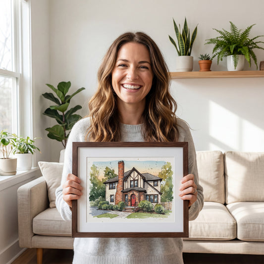 Woman holding a framed painting of a house in a living room with plants and a couch.